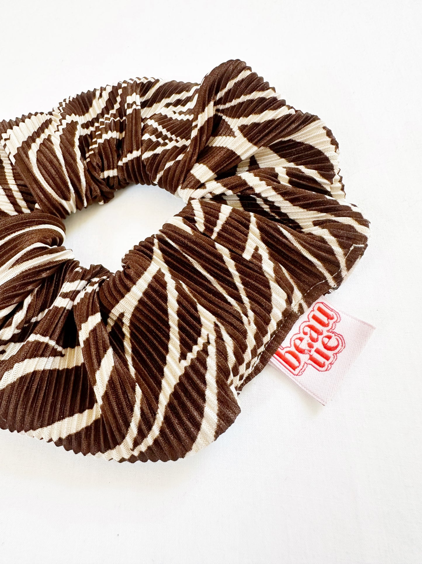 The OG scrunchie in brown leaf plisse
