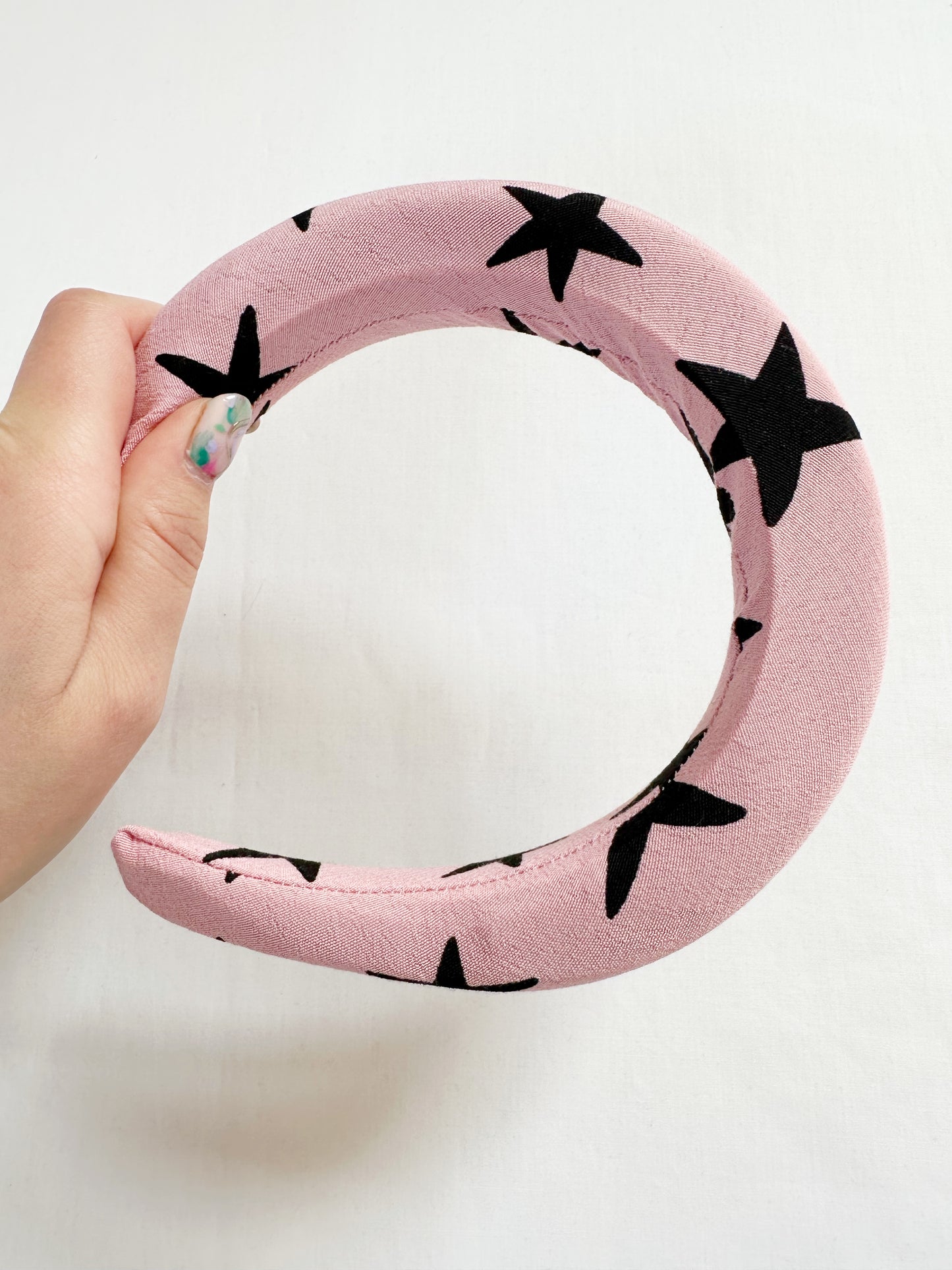 Padded headband in pink and black star print.