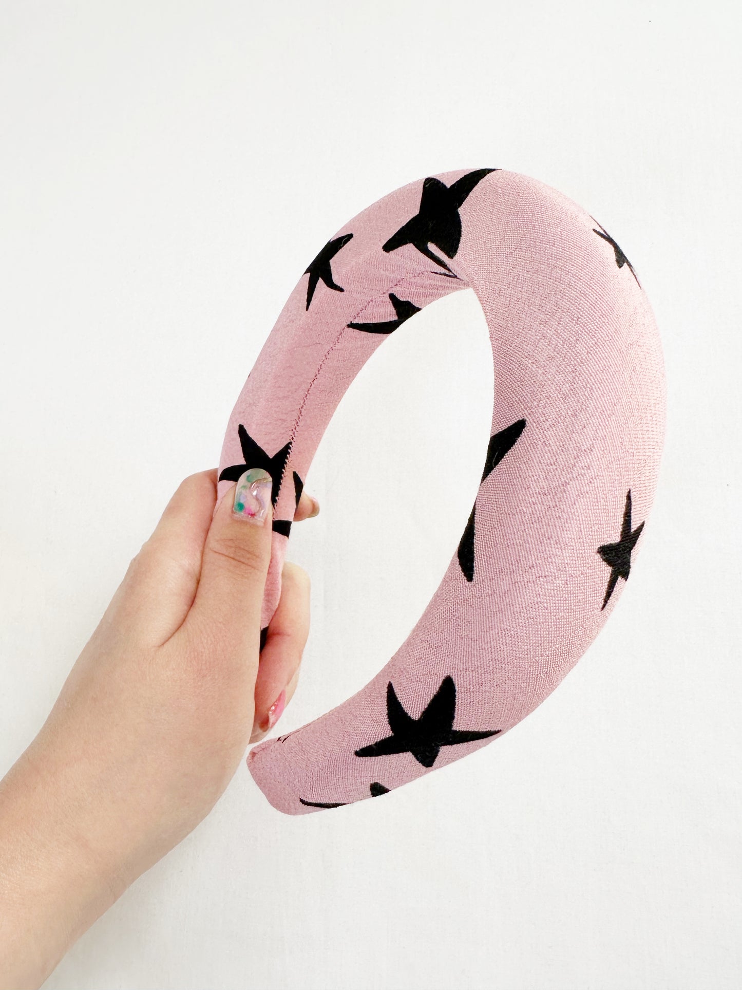 Padded headband in pink and black star print.