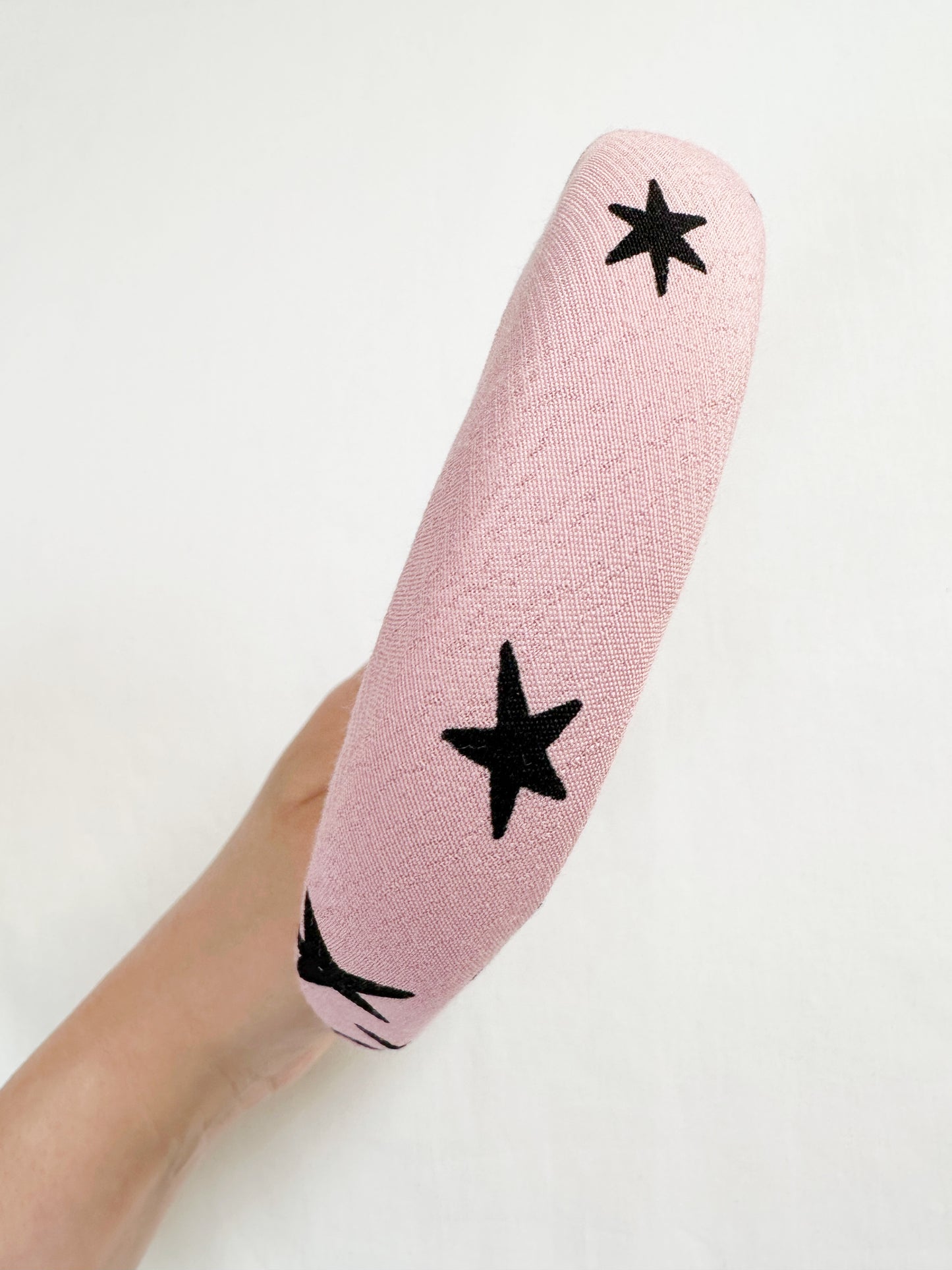 Padded headband in pink and black star print.