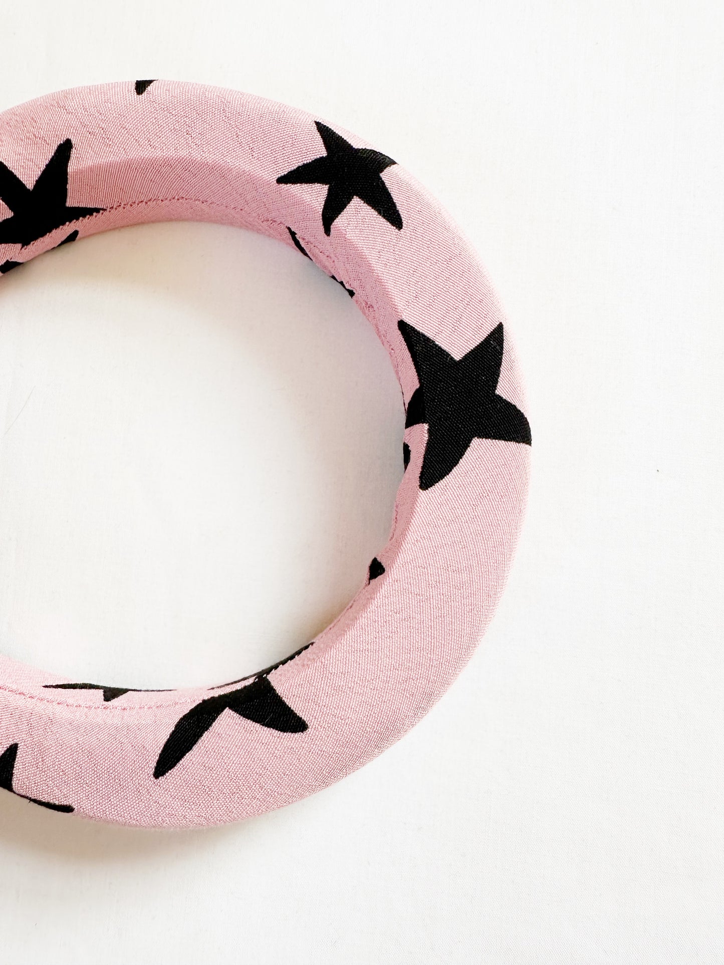 Padded headband in pink and black star print.