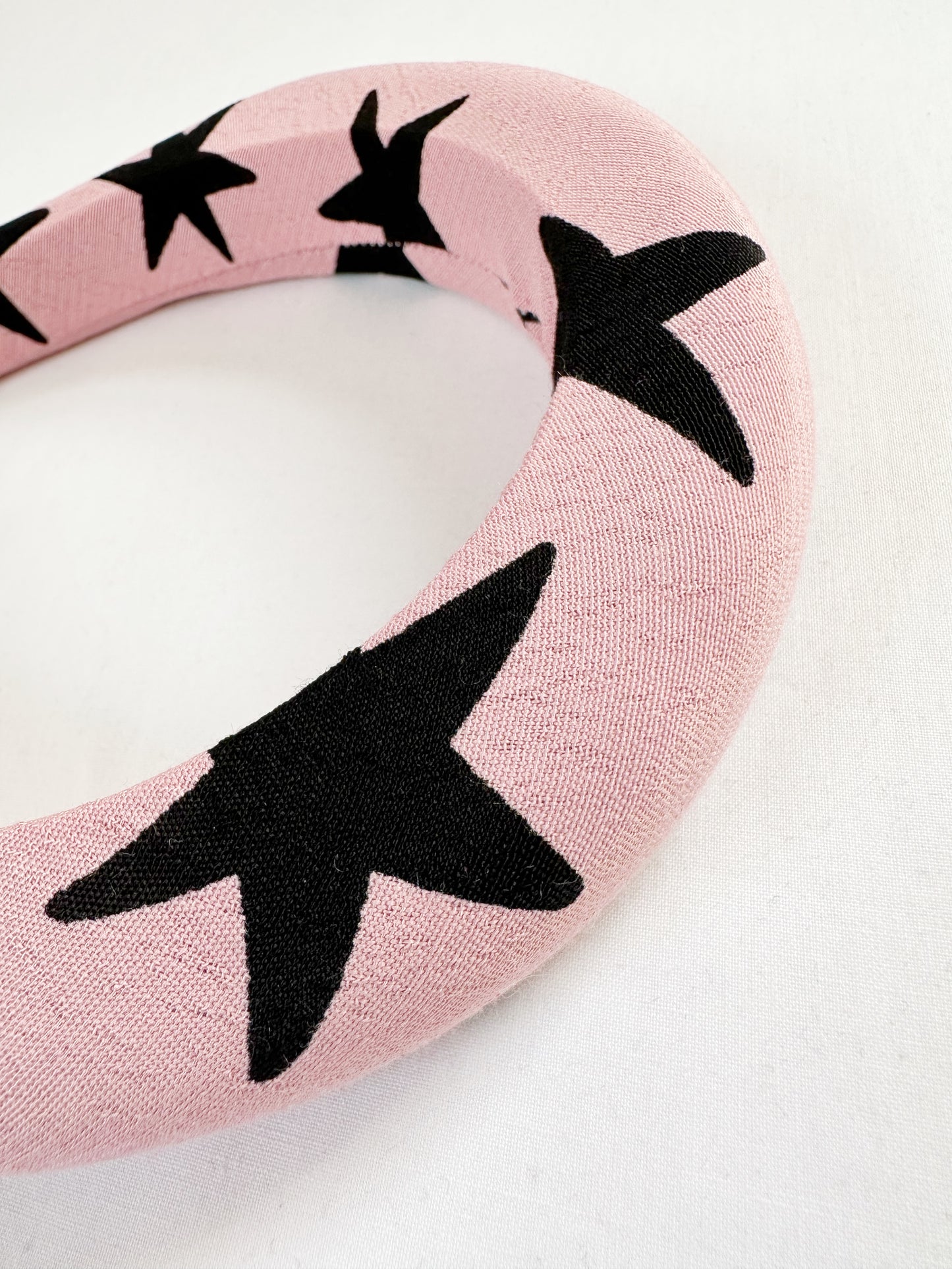 Padded headband in pink and black star print.