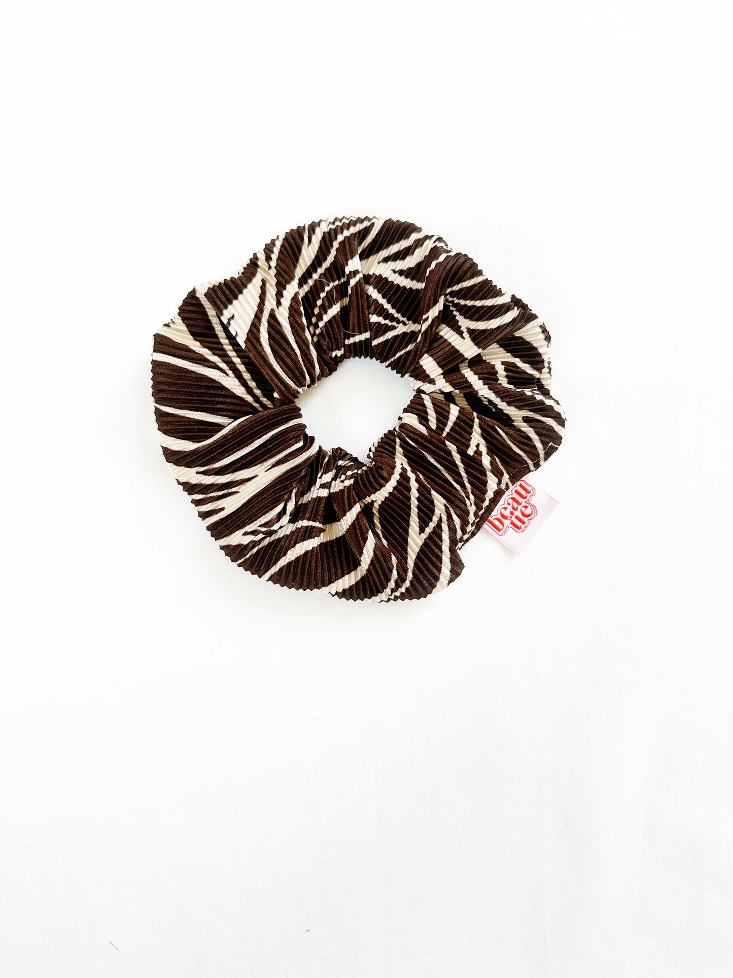 The OG scrunchie in brown leaf plisse